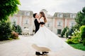 beautiful newlyweds dancing and whirling against the background of a building.