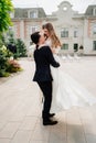 beautiful newlyweds dancing and whirling against the background of a building. Royalty Free Stock Photo