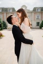 beautiful newlyweds dancing and whirling against the background of a building.