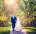 Beautiful newlyweds walking in a green park.