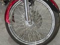 Beautiful nickel plated front wheel of a red motorcycle