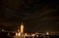 Beautiful night cityscape with stars whirling above the steeple