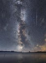 Beautiful night landscape, bright panoramic milky way galaxy under lake and mountains.