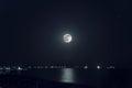 A beautiful night landscape of full moon over dark water with reflections on it Royalty Free Stock Photo