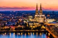 Beautiful night landscape of the gothic Cologne cathedral, Hohenzollern Bridge and the River Rhine at sunset and blue hour in Royalty Free Stock Photo