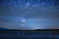 Beautiful night landscape on the starry sky and clouds, panoramic view on the lake and mountains. Royalty Free Stock Photo