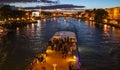 Beautiful night Paris, sparkling Eiffel tower, bridge Pont des Arts over the River Seine and touristic boats. France