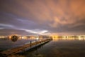 Beautiful night reflections in the sea from the port and moving clouds