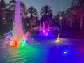 A beautiful night singing fountain with jets of water and splashes with multi-colored illumination against the backdrop of Royalty Free Stock Photo