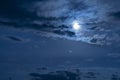 Beautiful night sky. The full moon illuminates clouds. Nature background.