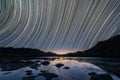 A beautiful night sky landscape with star trails reflecting in the Orange River
