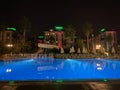 Beautiful night swimming pool with umbrellas and deck chairs and palm trees in a hotel on vacation in a tourist warm tropical Royalty Free Stock Photo