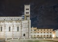 Beautiful night view of the Cathedral of San Martino with cloudy sky from which the moon appears, Lucca, Tuscany, Italy Royalty Free Stock Photo