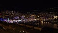 Beautiful night view of the harbor of Monaco (Port Hercule) at the French Riviera with colorful funfair.