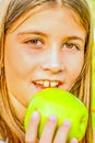 Beautiful nine year old girl eating apple