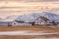 Beautiful norwegian winter sunset landscape, white house on the seacoast on the snowy rocky mountains background Royalty Free Stock Photo