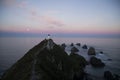 Nugget Point Lighthouse. Pink sunset sky with the moon, South Island, New Zealand Royalty Free Stock Photo