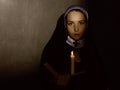 Beautiful nun with a candle reading the Bible. religious concept