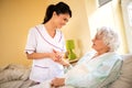 Beautiful nurse holding hand of old senior patient and comfort h Royalty Free Stock Photo