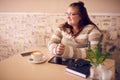 Beautiful obese caucasian woman in cafe looking into window light