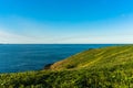 Beautiful ocean view and green grassy hill with Royalty Free Stock Photo