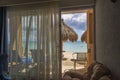 Beautiful ocean view and puffy clouds on blue sky from open glass door of hotel room. Royalty Free Stock Photo