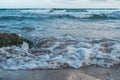 Beautiful ocean waves hitting the sandy beach under the cloudy sky Royalty Free Stock Photo