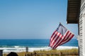 A beautiful oceanfront property with a classic American flag on the side of it with the coastline in the background. Royalty Free Stock Photo