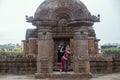 Beautiful odissi dancer posing before Mukteshvara Temple in bhubaneswar,made of red stone and with sculptures