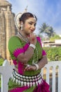 Beautiful Odissi dancer striking pose against the backdrop of Lingaraja Temple in bhubaneswar, Odisha, India