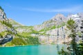 Beautiful Oeschinen Lake, Oeschinensee in Switzerland photographed on a sunny day. Turquoise lake with rocky mountains in