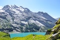 Beautiful Oeschinensee lake near Kandersteg in Switzerland. Turquoise lake surrounded by steep snow-capped mountains. Popular