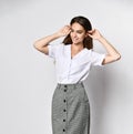Beautiful woman office manager posing in a new casual white blouse and classic straight dark skirt