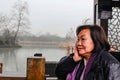 Beautiful Old asian women traveler very relax and tranquil in the park of hangzhou city