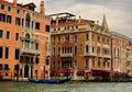 Beautiful old bright houses near the canal with gondola in Venice, Italy under blue sky Royalty Free Stock Photo