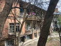 Beautiful old brown dilapidated three-story house with windows and balconies, slum terraces in the old urban area of Tbilisi. Royalty Free Stock Photo