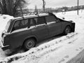 Beautiful old car with a cover on the hood in the snow