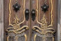 Beautiful old door knocker, carved architectural elements, door handles, brown and gold colors. Close-up photo Royalty Free Stock Photo