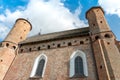 A beautiful old fortress church made of red brick against a blue sky background. A high impregnable fortress with iron crosses on