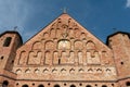 A beautiful old fortress church made of red brick against a blue sky background. A high impregnable fortress with iron crosses on