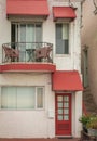 Beautiful old house with windows and balcony with flower pots. White house facade with red color door and windows Royalty Free Stock Photo