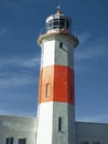 Beautiful old lighthouse, red white, isolated on blue sky background Royalty Free Stock Photo