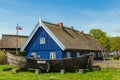 Beautiful old Lithuanian traditional wooden house with thatched roof and boat Royalty Free Stock Photo