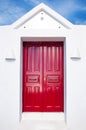 Beautiful old red door on white facade of greek architecture against the blue sky, Santorini island, Greece, Europe. Beautiful Royalty Free Stock Photo