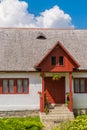 Beautiful old romanian traditional house with wood tiles roof, front entrance porch, flowers and windows. Royalty Free Stock Photo