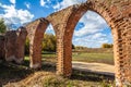 Beautiful old ruined castle of red bricks with arches at autumn on green grass background Royalty Free Stock Photo