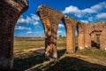 Beautiful old ruined castle of red bricks with arches at autumn on green grass background Royalty Free Stock Photo