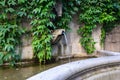 Beautiful old stone fountain is streaming and running clear water. Traditional multi jet round fountain in the style of European