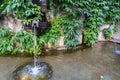 Beautiful old stone fountain is streaming and running clear water. Traditional multi jet round fountain in the style of European