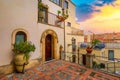 Beautiful old town of Taormina with small streets, flowers. Architecture with archs and old pavement in Taormina. Colorful narrow